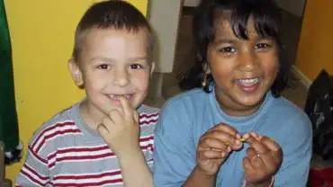 To børn med forskellig hudfarve smiler
